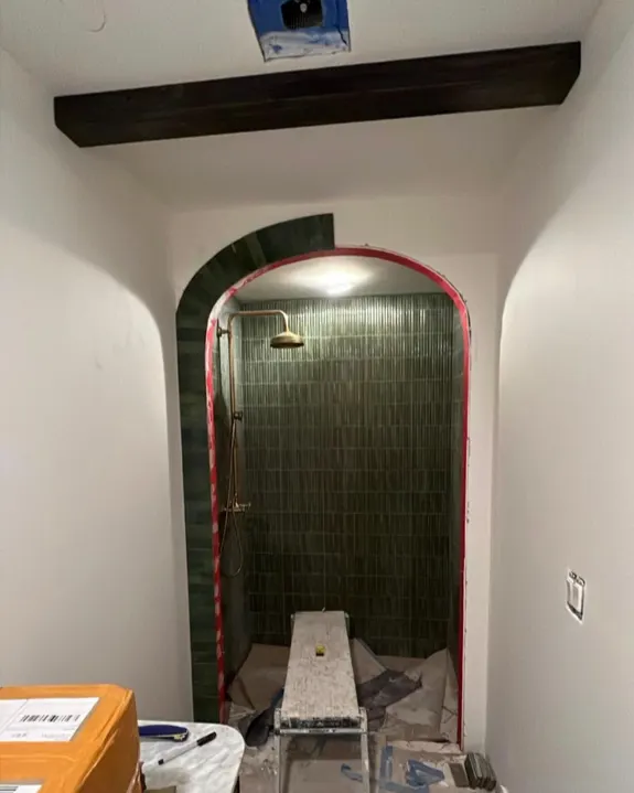 Before: Bathroom with arched green-tile shower