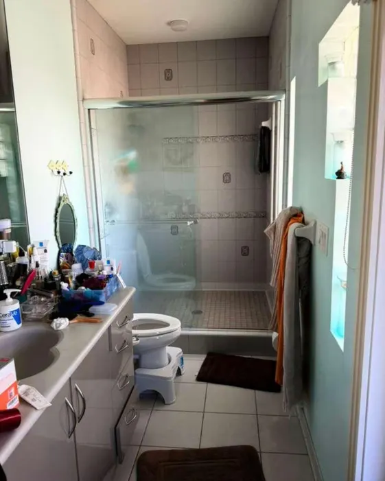 Before: Bathroom with wood vanity & glass shower