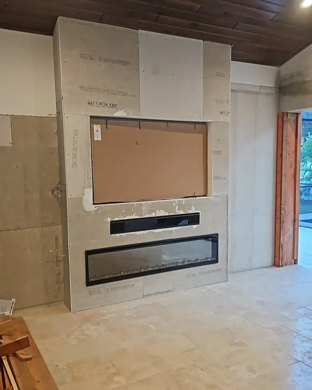 Antes: Salón con chimenea y pared de TV en piedra